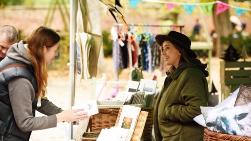 Visitor talking to stallholder on their market stall